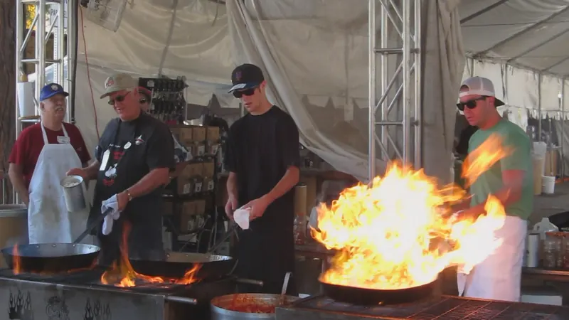 Chefs cooking calamari over open flames in Gourmet Alley at the Gilroy Garlic Festival
