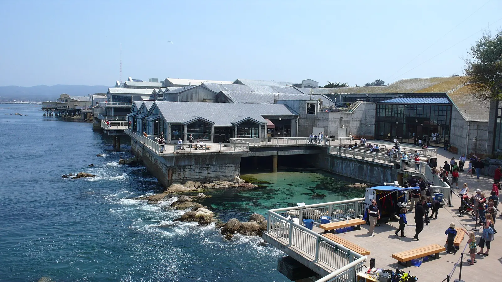 The Monterey Bay Aquarium buildings and tide pool deck on the rocky shore of Monterey Bay